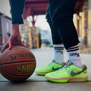 Person wearing curbside classic crew socks with stripes holding a basketball wearing nike sneakers